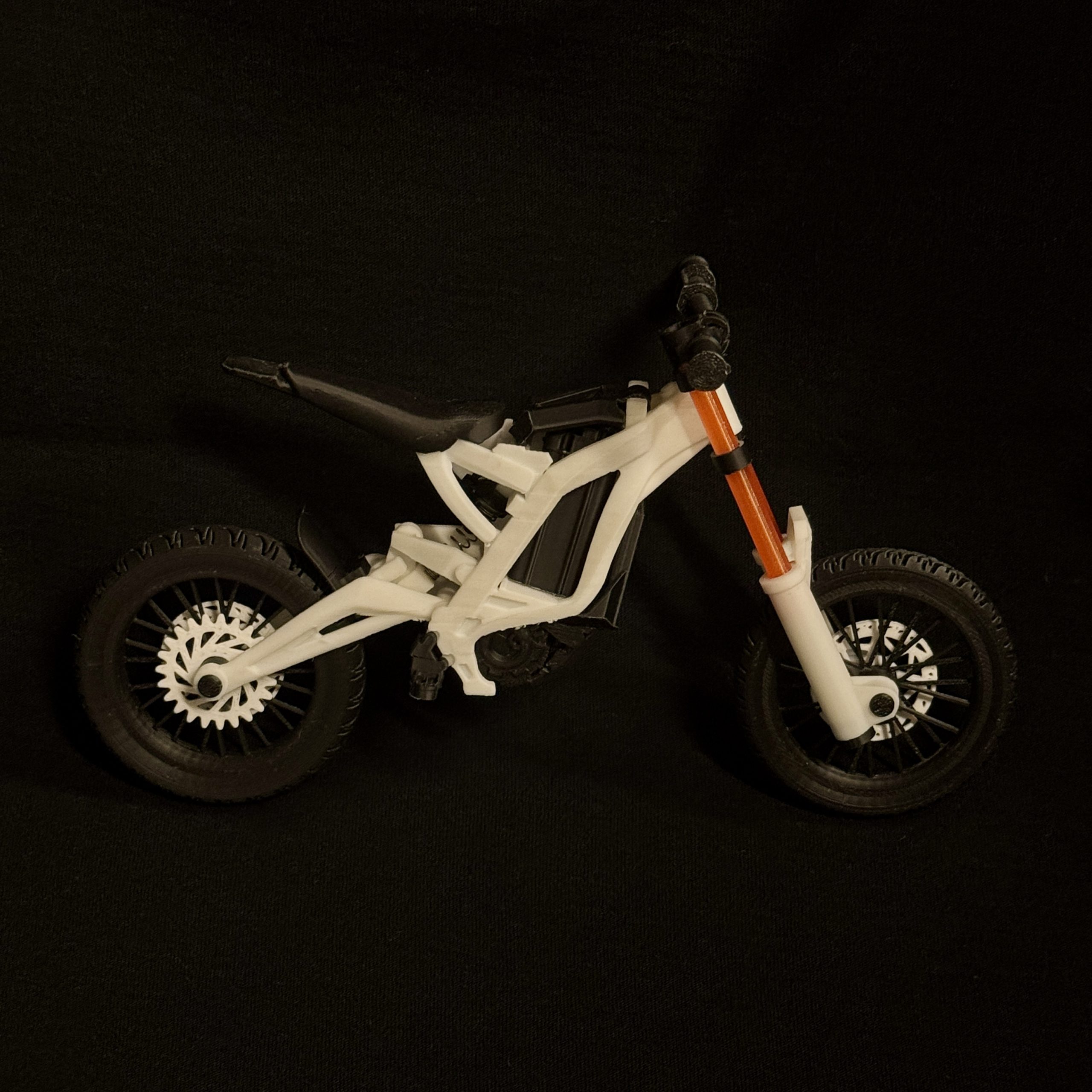 SurRon Mini 3D modelis žalios spalvos su bekelės ratais ant stalo